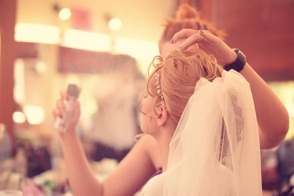 Maquillaje artista aplicar spray en el cabello de la mujer — Foto de Stock