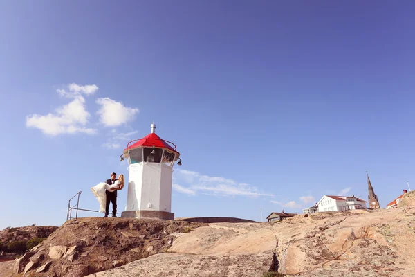 Bride and groom near lighthouse — Stock Photo, Image