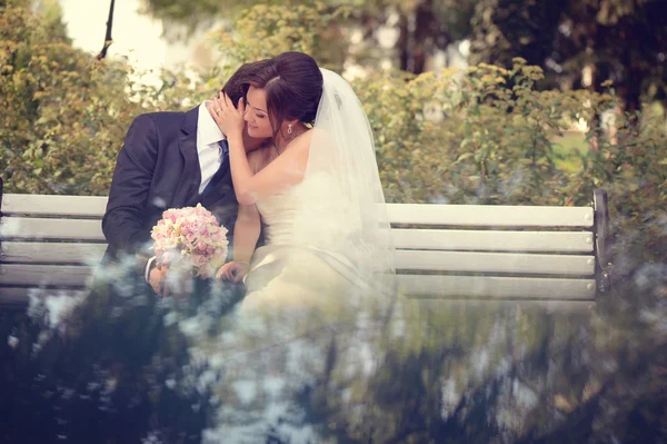Noiva e noivo sentados no banco — Fotografia de Stock