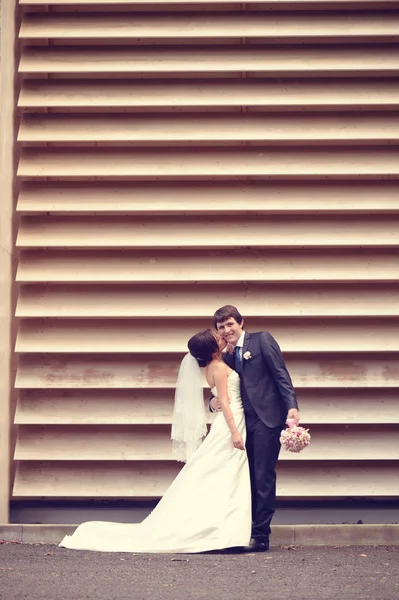 Noiva e noivo dançando contra a parede listrada — Fotografia de Stock