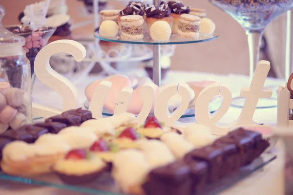 Letras dulces en la mesa con postres — Foto de Stock