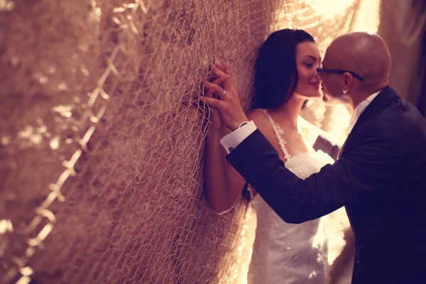 Noiva e noivo contra uma parede com trammel — Fotografia de Stock