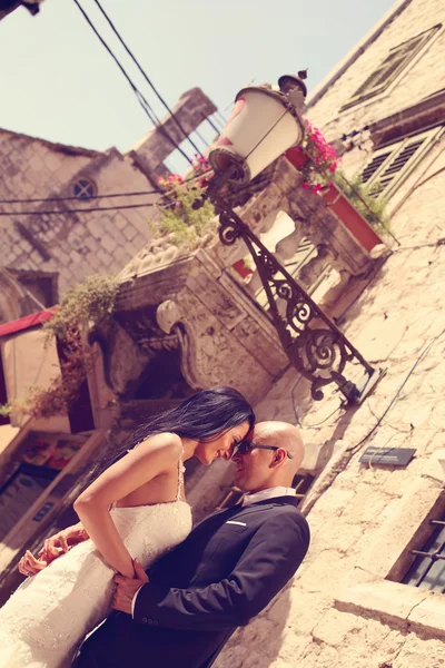 Bride and groom embracing and holding hands — Stock Photo, Image