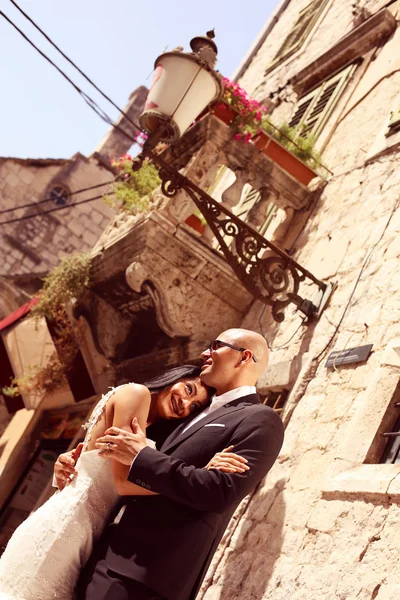 Bride and groom embracing and holding hands — Stock Photo, Image