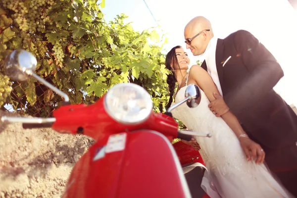Mariée et marié près d'un scooter rouge — Photo