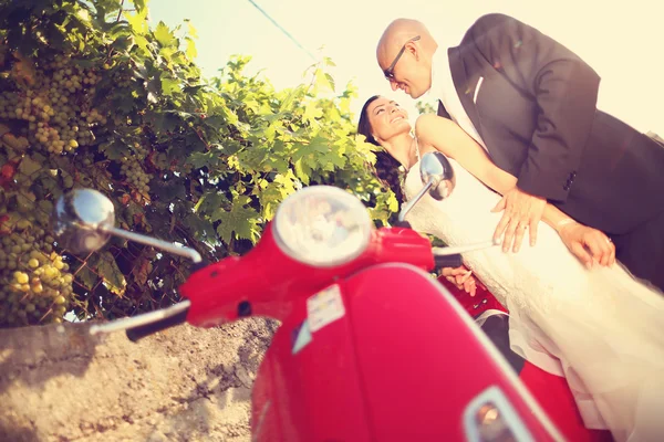 Novia y novio cerca de un scooter rojo — Foto de Stock