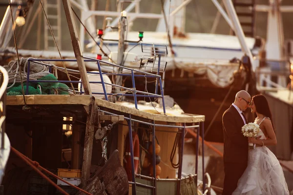 Bruid en bruidegom knuffelen in een haven — Stockfoto