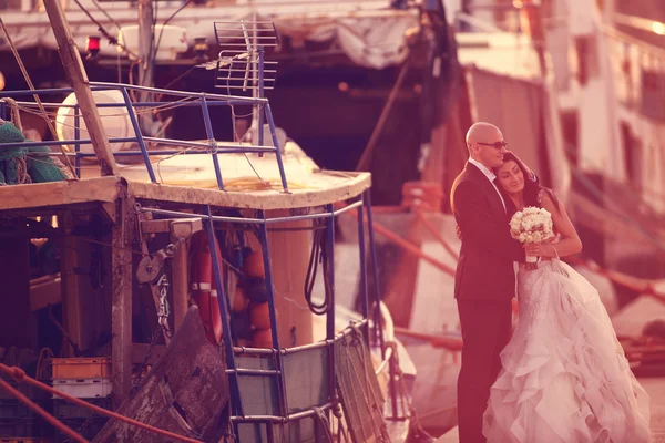 Bride and groom hugging in a harbor — Stock Photo, Image