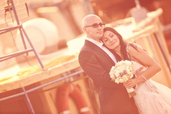 Noiva e noivo abraçando em um porto — Fotografia de Stock