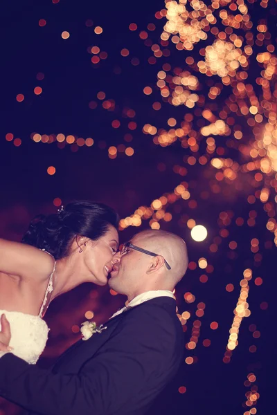 Bride and groom surrounded by fire crackers — Stock Photo, Image