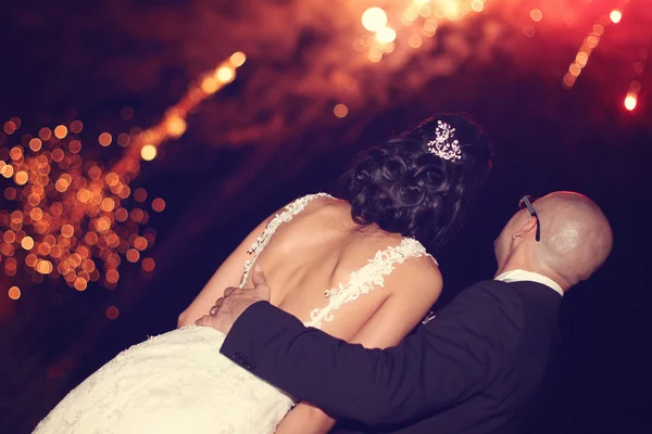 Bride and groom surrounded by fire crackers — Stock Photo, Image