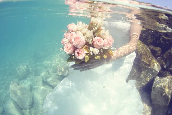 Ruce držel pod vodou svatební kytice nevěsty — Stock fotografie
