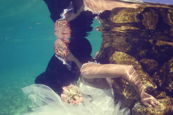 Bruid en bruidegom kussen onderwater — Stockfoto