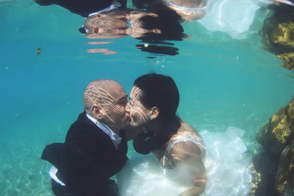 Bride and groom kissing underwater — Stock Photo, Image