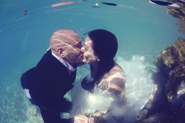 Bride and groom kissing underwater — Stock Photo, Image