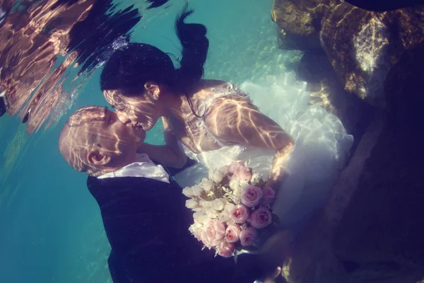 Bride and groom kissing underwater — Stock Photo, Image