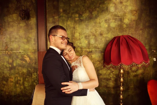 Braut und Bräutigam umarmen sich in einem Vintage-Zimmer — Stockfoto