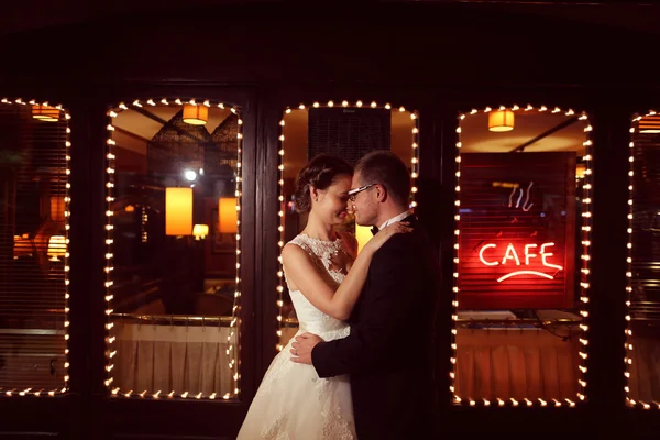 Νύφη και ο γαμπρός αγκαλιάζοντας μπροστά από ένα καφέ μπαρ — Φωτογραφία Αρχείου