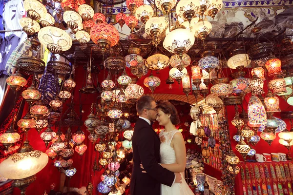 Bride and groom surrounded by turkish lamps — Stock Photo, Image