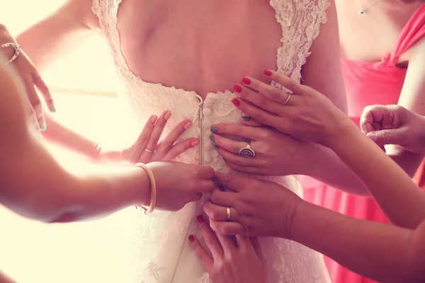 Manos ayudando a la novia con el vestido de novia — Foto de Stock