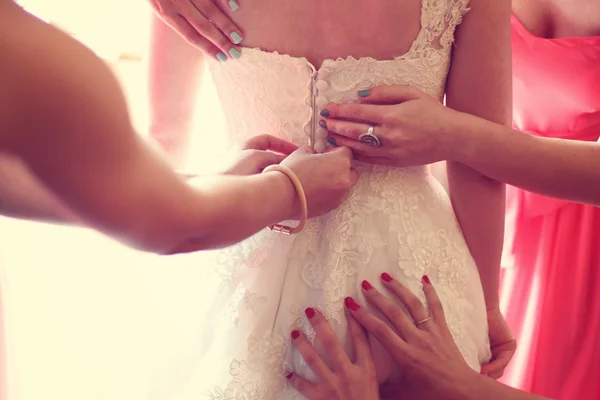 Handen helpen van de bruid met de trouwjurk — Stockfoto