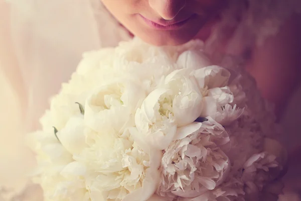 Mains d'une mariée tenant un bouquet de pivoines blanches — Photo