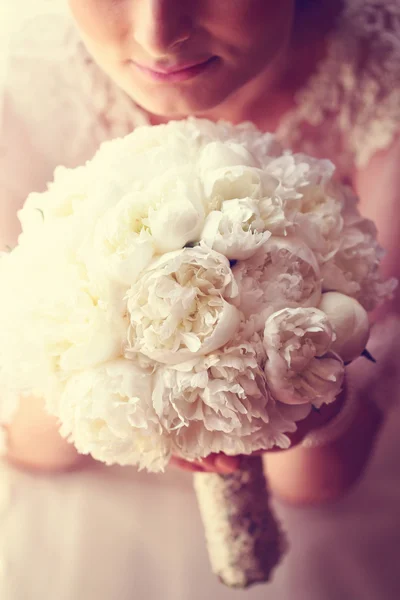 Hands of a bride holding white peonies bouquet — Stock Photo, Image