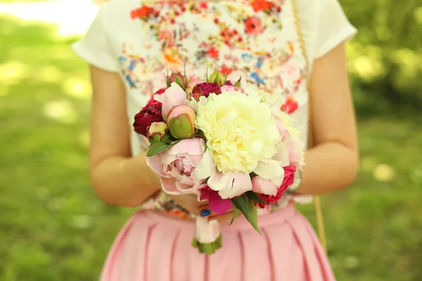 Handen van een vrouw met prachtige pioenrozen boeket — Stockfoto