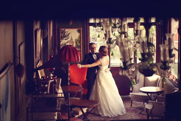 Novia y novio bailando en una hermosa habitación — Foto de Stock