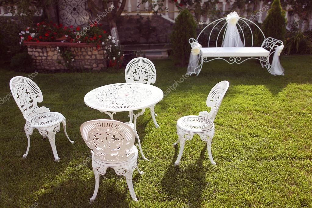 White cast iron chairs and table in the garden Stock Photo by