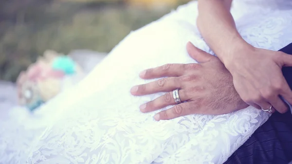 Kezében a menyasszony és a vőlegény jegygyűrűt viselt — Stock Fotó