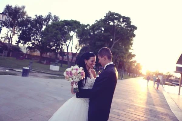 Bruden och brudgummen vid solnedgången — Stockfoto