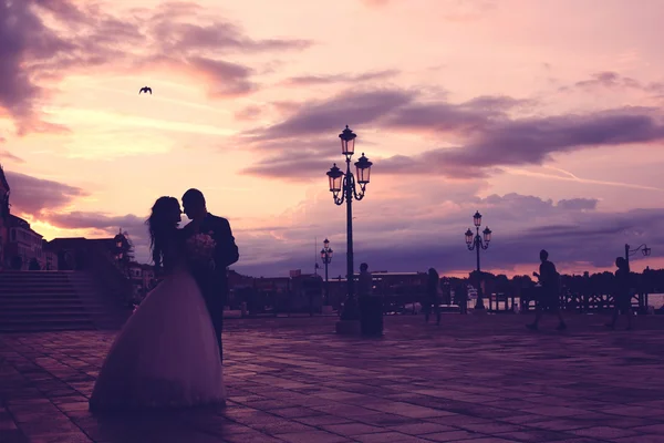Bruden och brudgummen på solnedgången i Venedig — Stockfoto