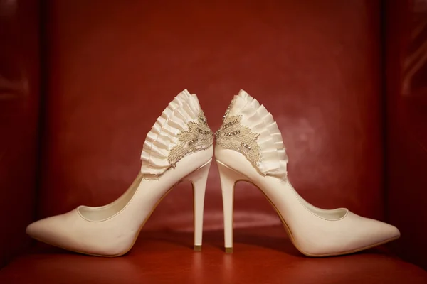 Sapatos de casamento no sofá vermelho — Fotografia de Stock