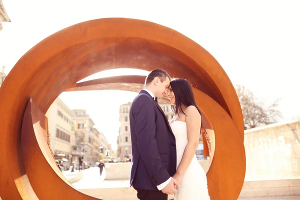 Noiva e noivo perto de objeto arquitetônico arredondado — Fotografia de Stock