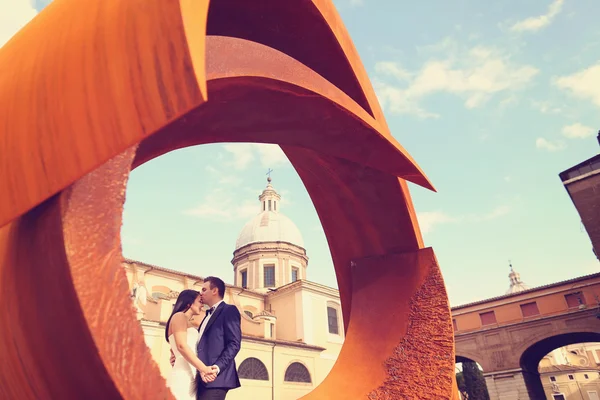 Noiva e noivo perto de objeto arquitetônico arredondado — Fotografia de Stock