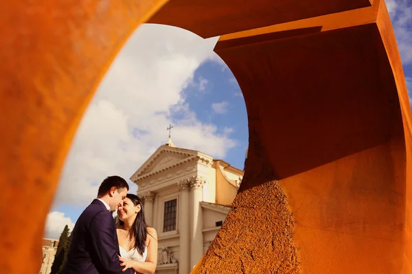 Наречений і наречений біля округленого архітектурного об'єкта — стокове фото