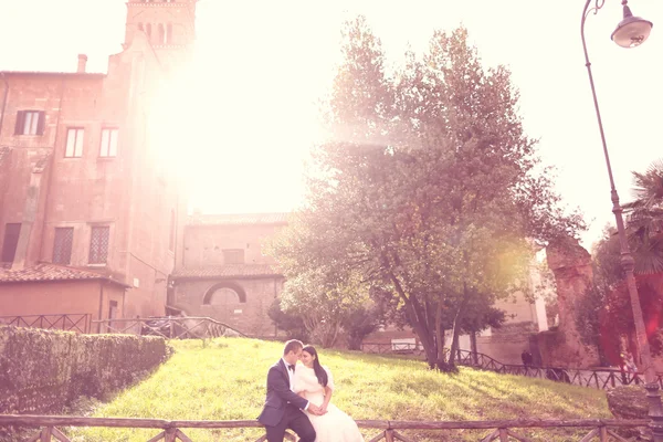 Mariée et marié sur une clôture en bois près du château — Photo