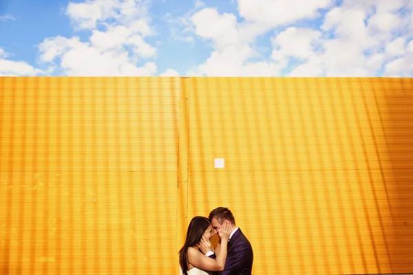 Mariée et marié sur mur jaune — Photo