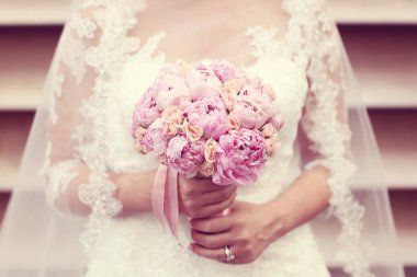 Eller peonies buket tutan bir gelin