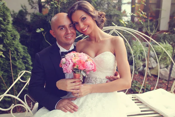 Bruden och brudgummen på vit bänk — Stockfoto