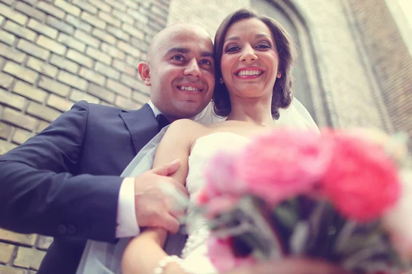 Happy bride and groom near church — Stock Photo, Image