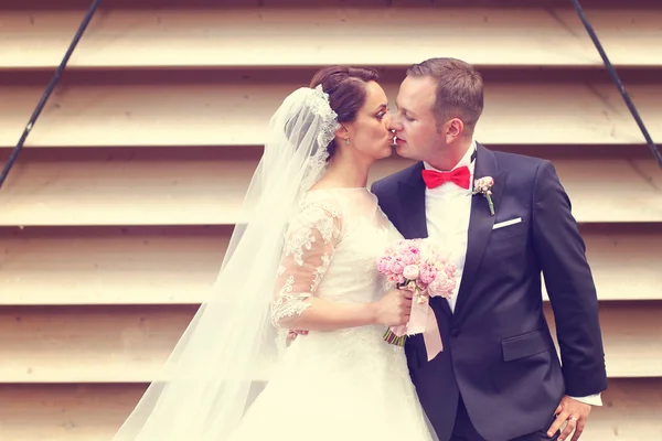 Braut und Bräutigam küssen sich neben abgerissener Mauer — Stockfoto