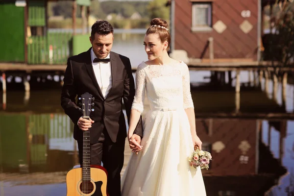 Bride and groom on a wooden bridge near lake — Stock Photo, Image