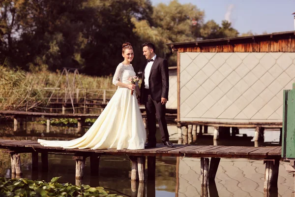 Bride and groom on wooden bridge — Stock Photo, Image