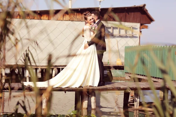 Bruid en bruidegom op houten brug — Stockfoto