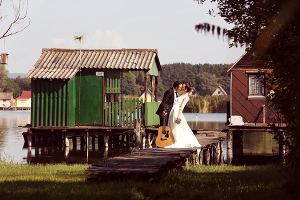 Brautpaar auf Holzbrücke am See — Stockfoto