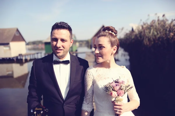 Happy bridal couple on lake house — Stock Photo, Image