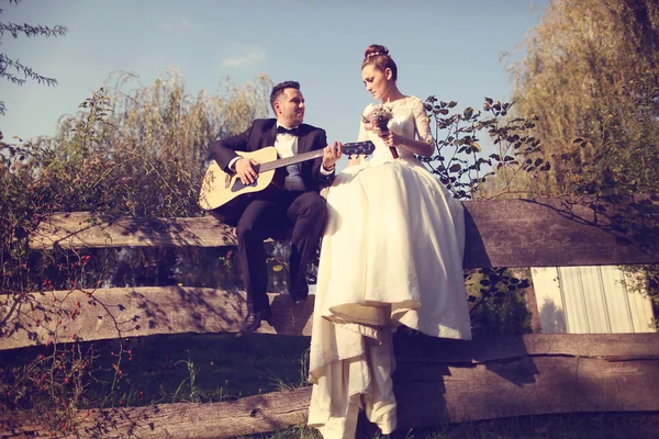 Brautpaar spielt an der Gitarre — Stockfoto