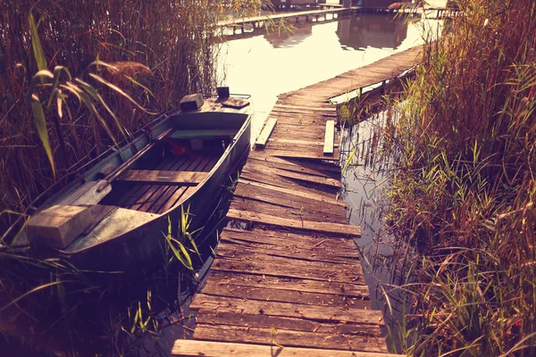 Barco cerca de camino de madera en el lago — Foto de Stock